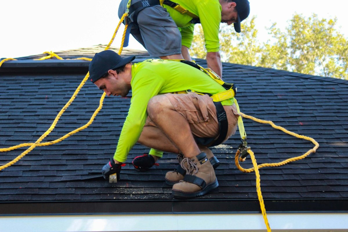 Deux couvreurs au travail sur la toiture d'une maison en rénovation